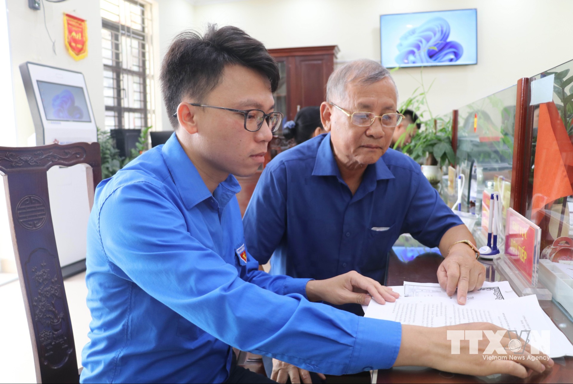 Đoàn viên thanh niên hướng dẫn người dân sử dụng dịch vụ công trực tuyến tại Trung tâm Phục vụ hành chính công xã Giao Bình, tỉnh Ninh Bình. (Ảnh: Thùy Dung/TTXVN)